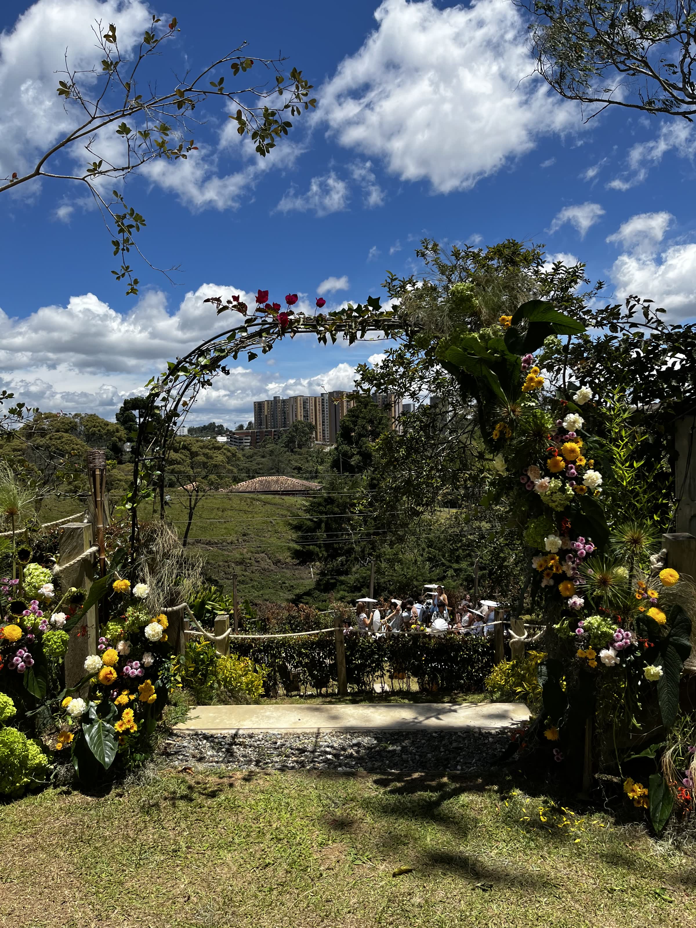 Arco floral con rosas en la ceremonia, invitados de fondo