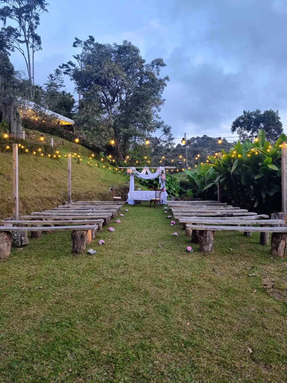 Montaje de ceremonia al anochecer con luces colgantes