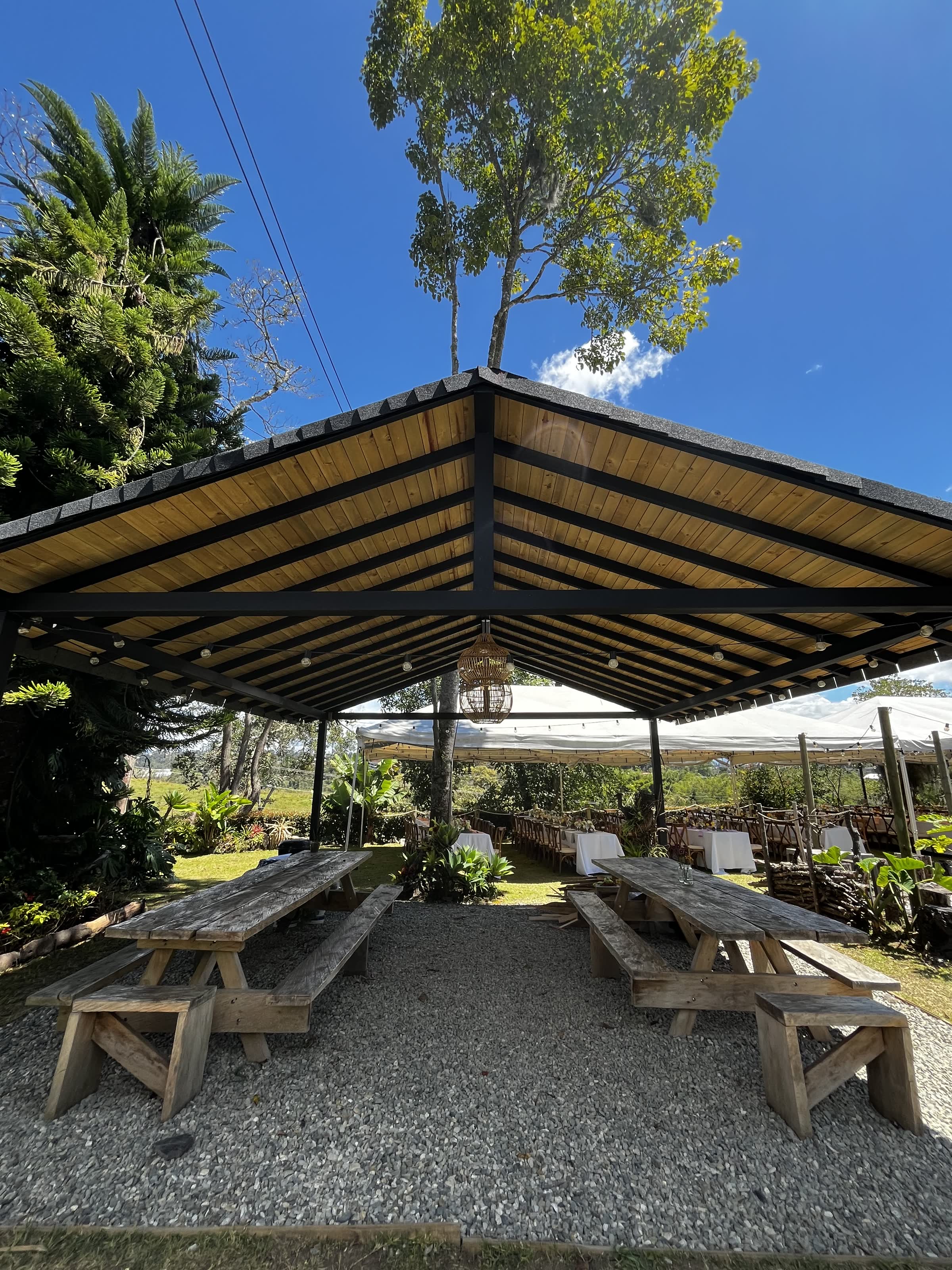 Kiosco de madera y mesas sobre zona de grava