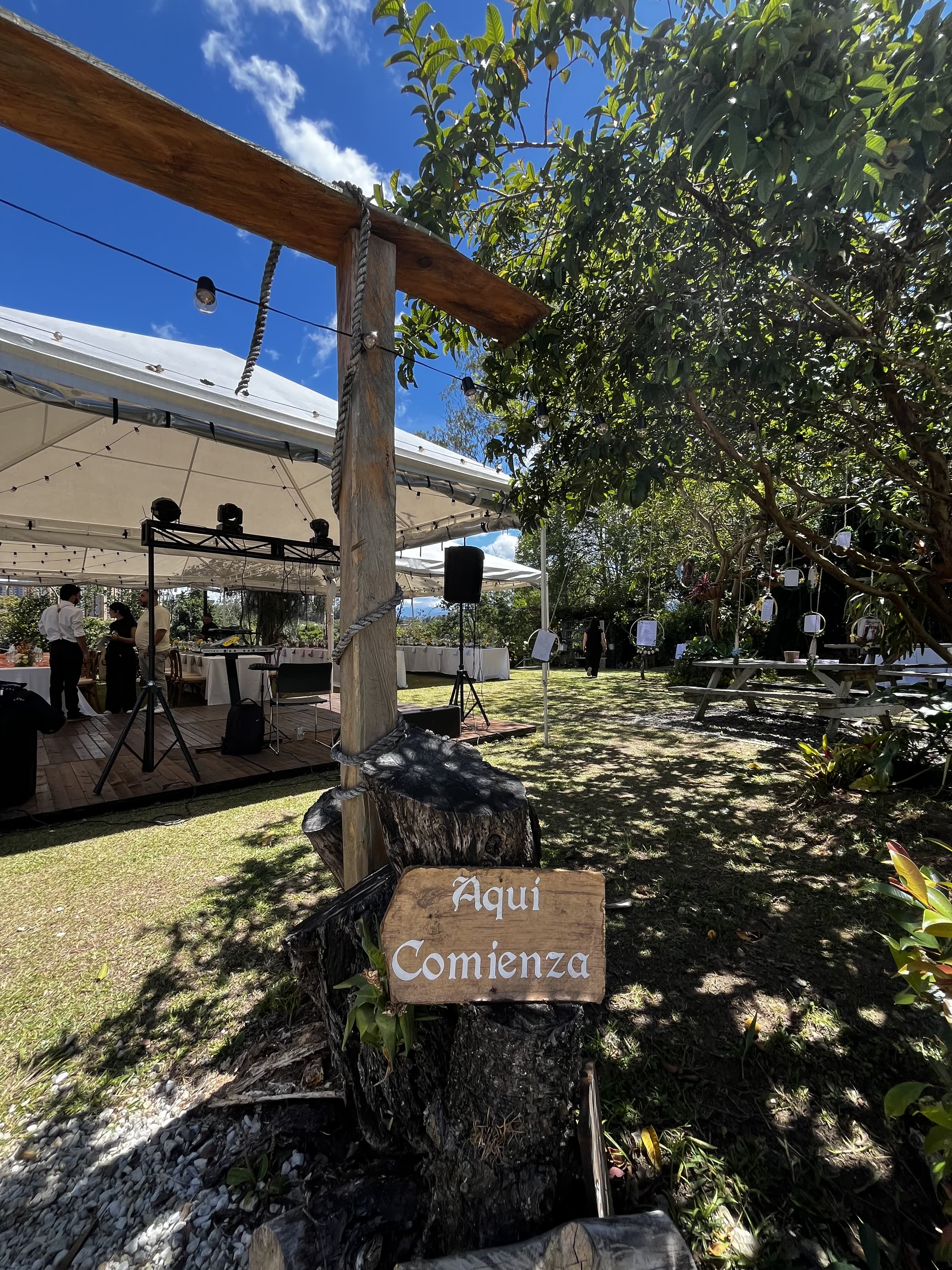 Letrero de madera "Aquí Comienza" en la entrada al jardín